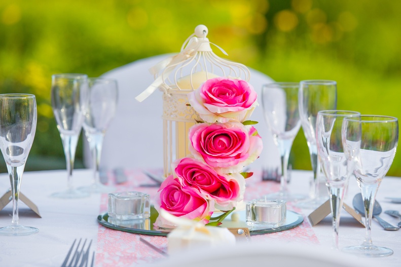 a table topped with a vase filled with pink roses.