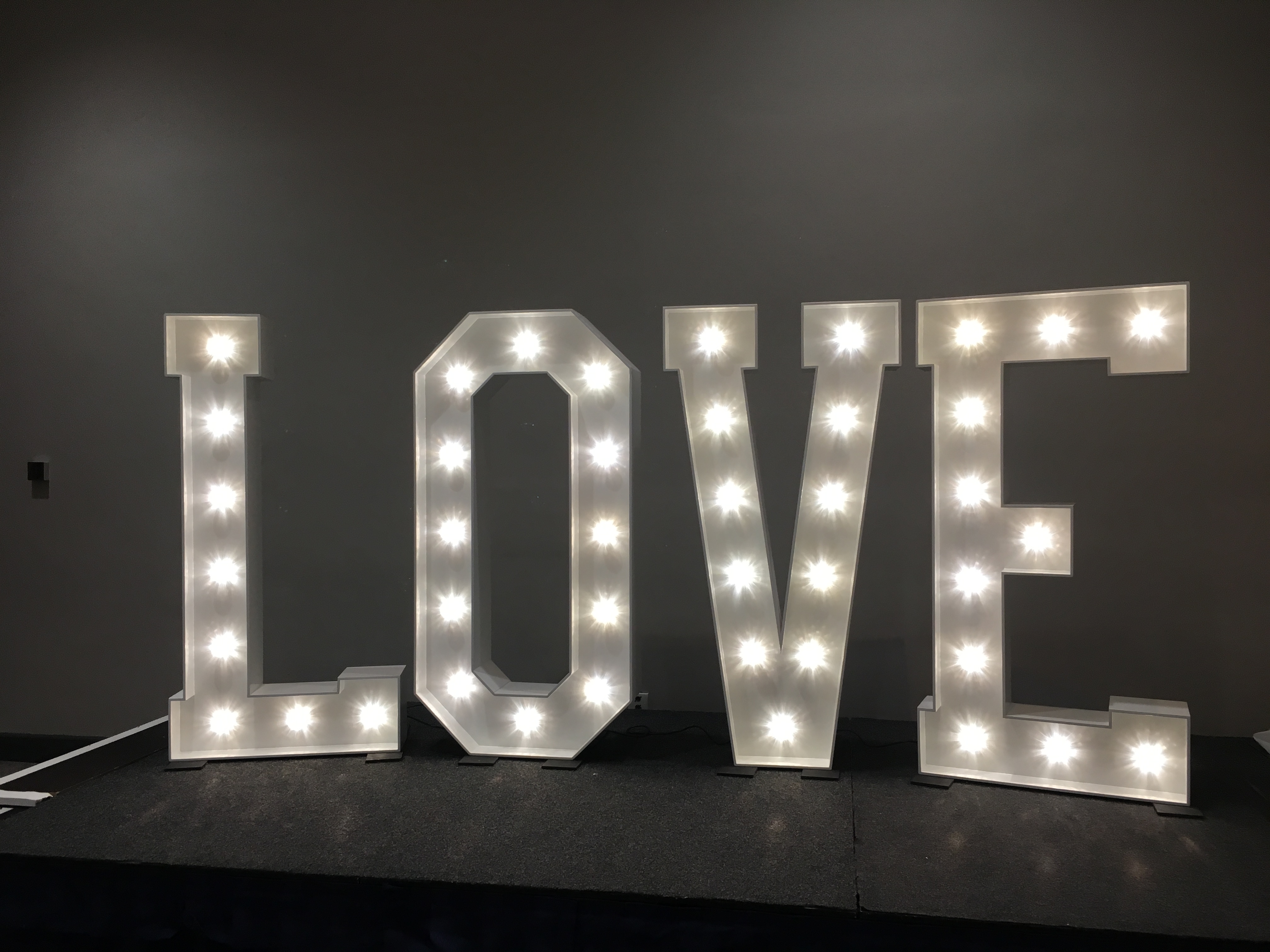 a lighted love sign sitting on top of a table.