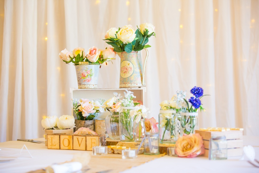 a table topped with lots of vases filled with flowers.