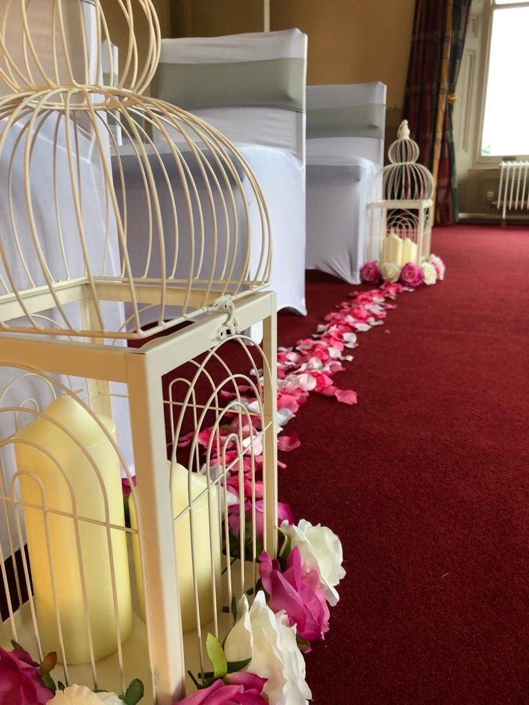 a row of bird cages with candles in them.