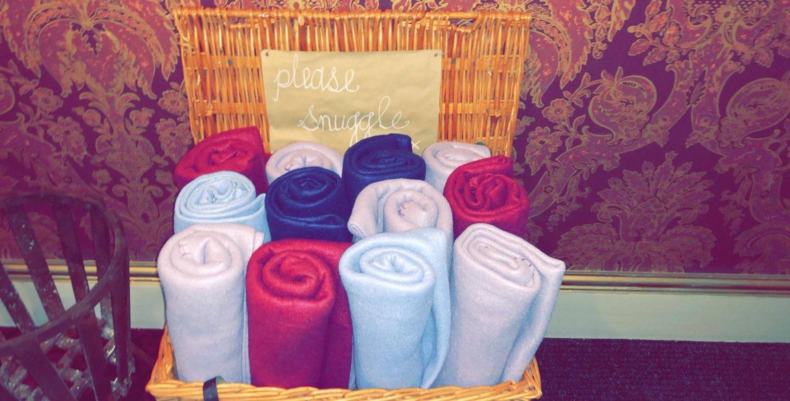 a basket filled with towels next to a chair.
