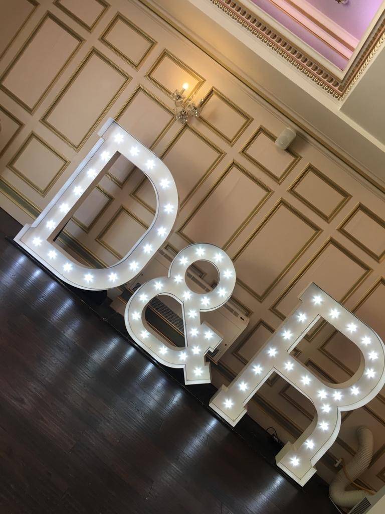 a large light up letters sitting on top of a wooden floor.