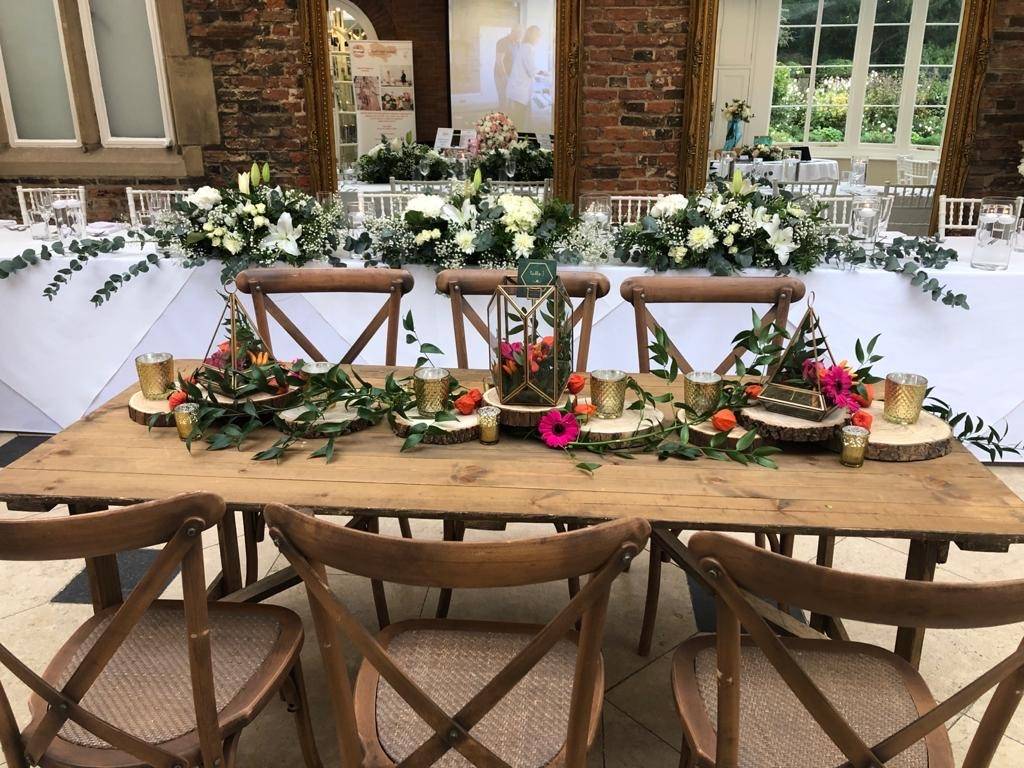 a wooden table topped with lots of flowers.