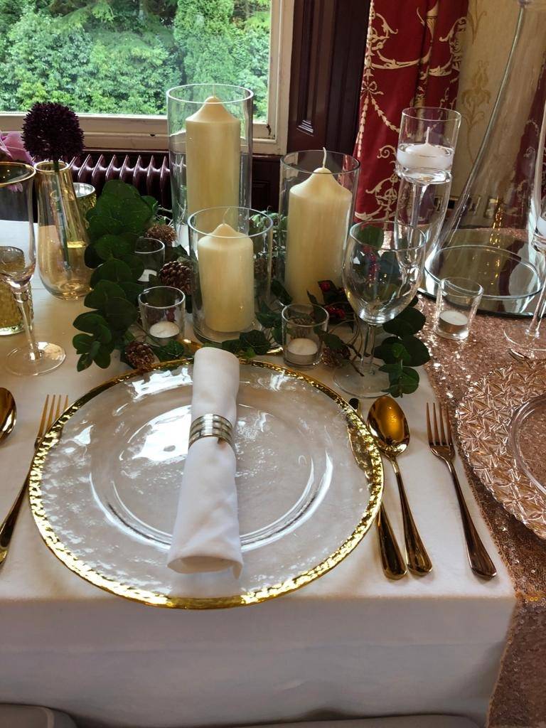 a place setting with candles, plates, and napkins.