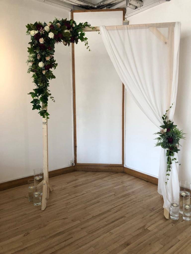a couple of vases filled with flowers on top of a wooden floor.