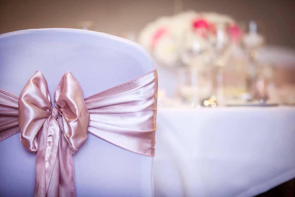 a close up of a chair with a bow on it.