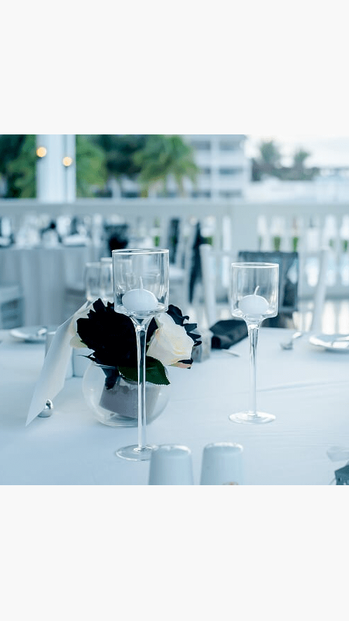 a white table topped with a vase filled with flowers.