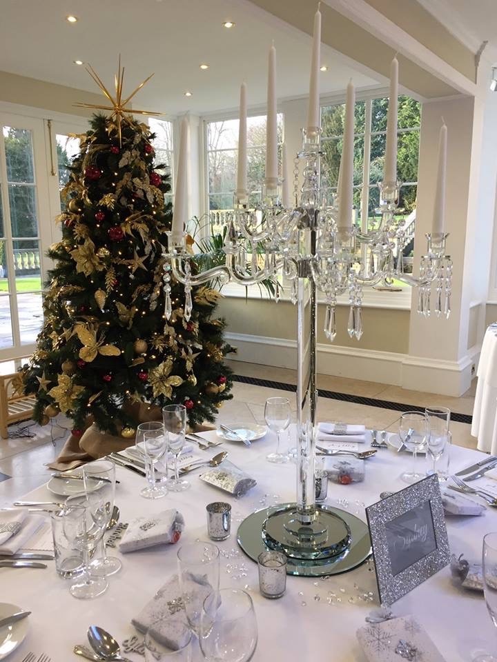 a dining room table with a christmas tree in the background.