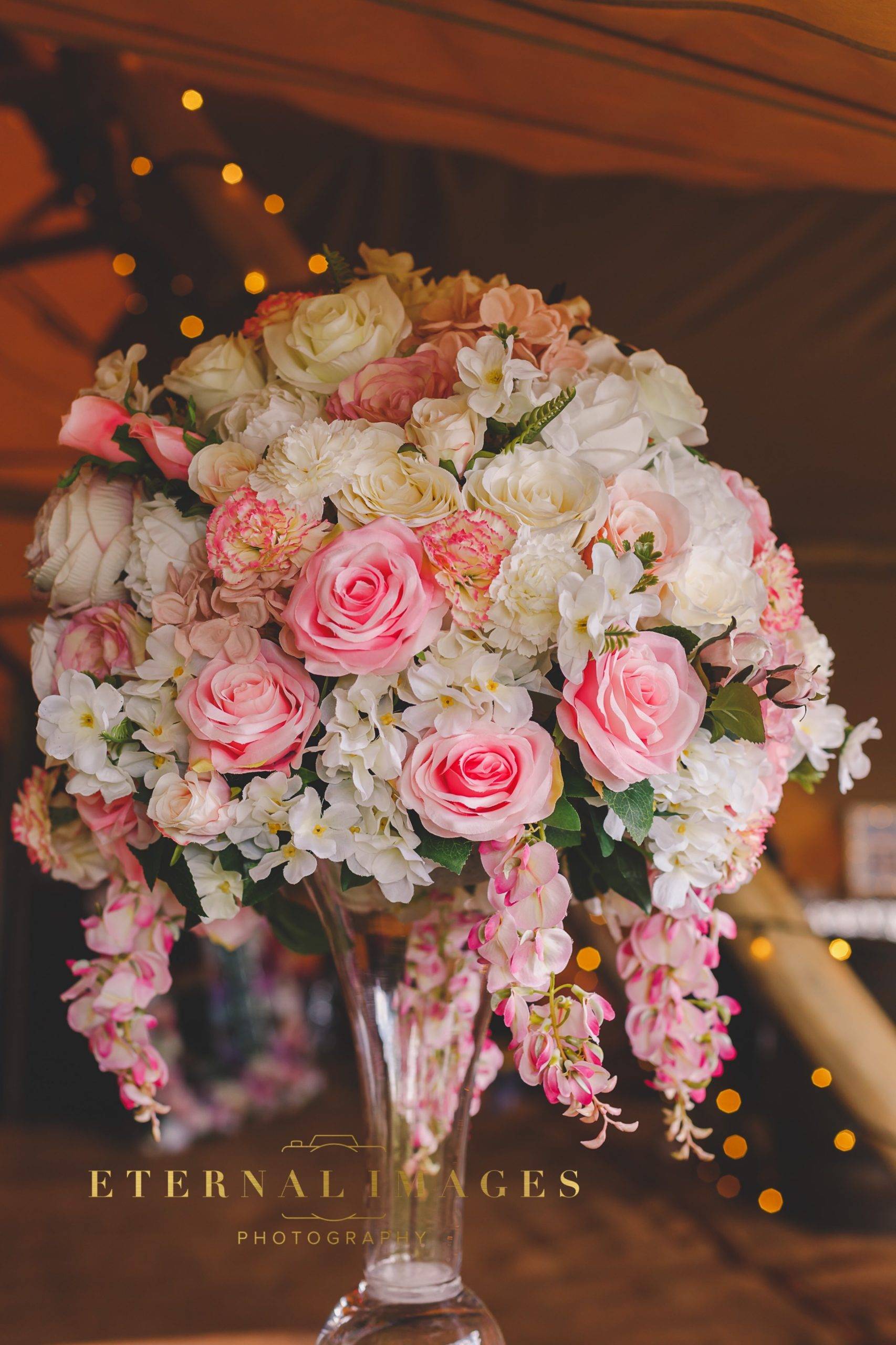 a vase filled with pink and white flowers.
