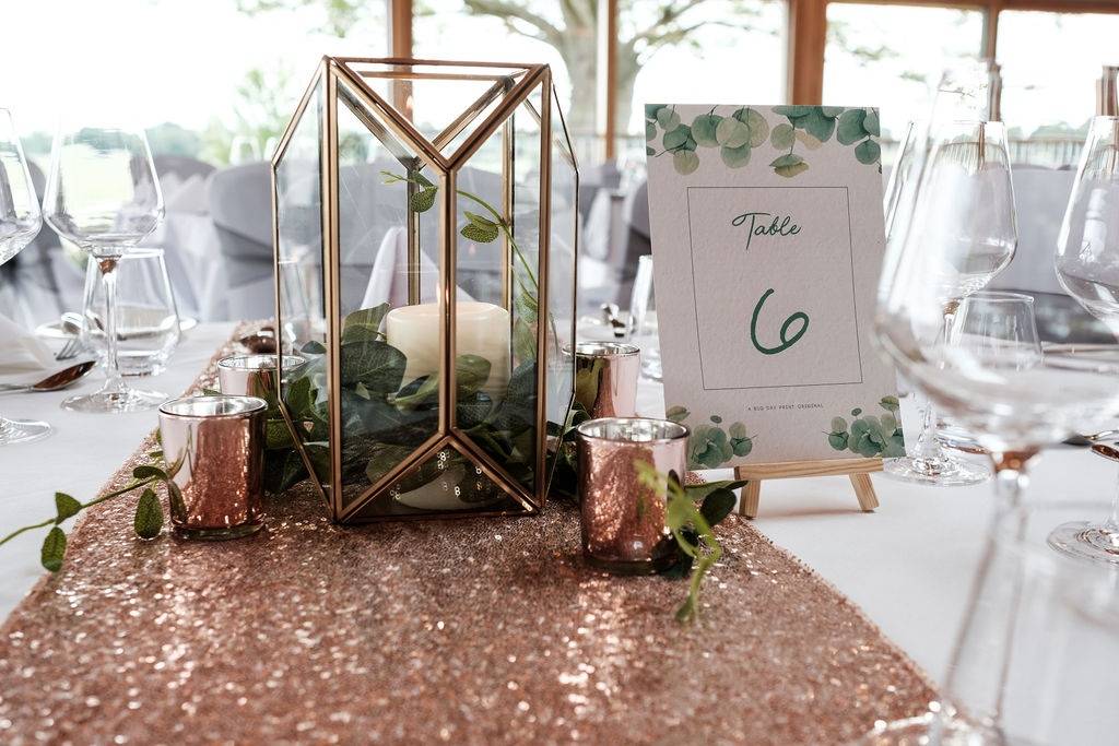 a table with a rose gold sequin table runner.