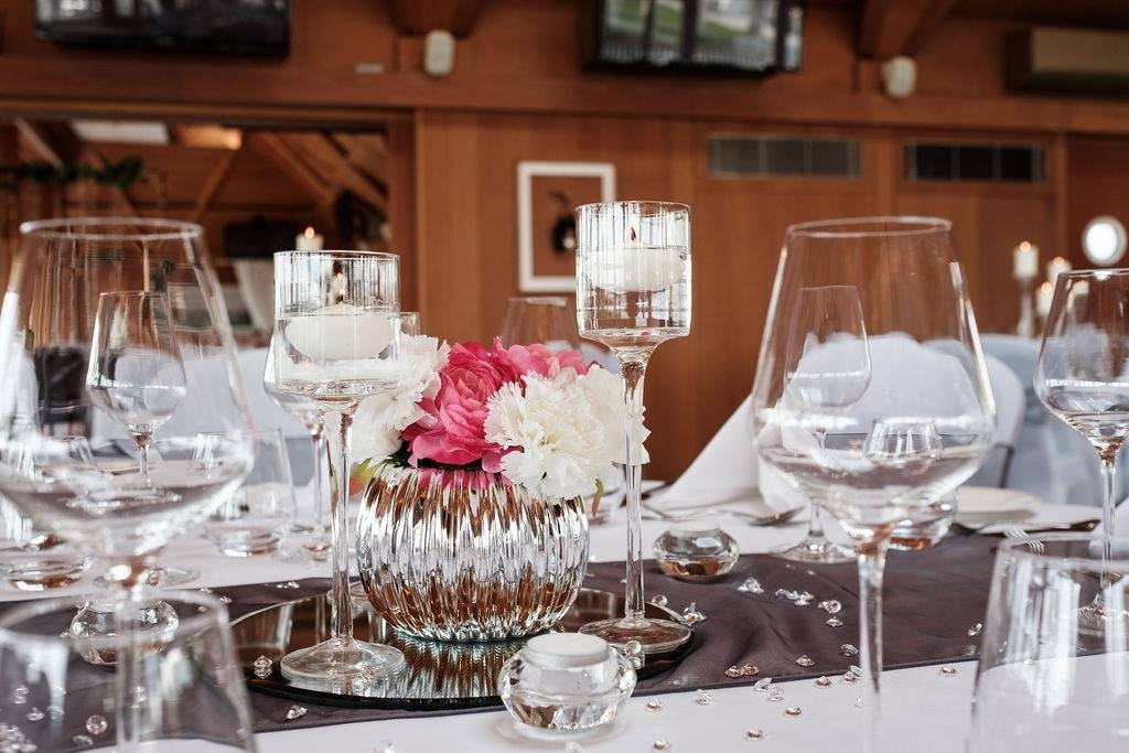 a table is set with wine glasses and flowers.