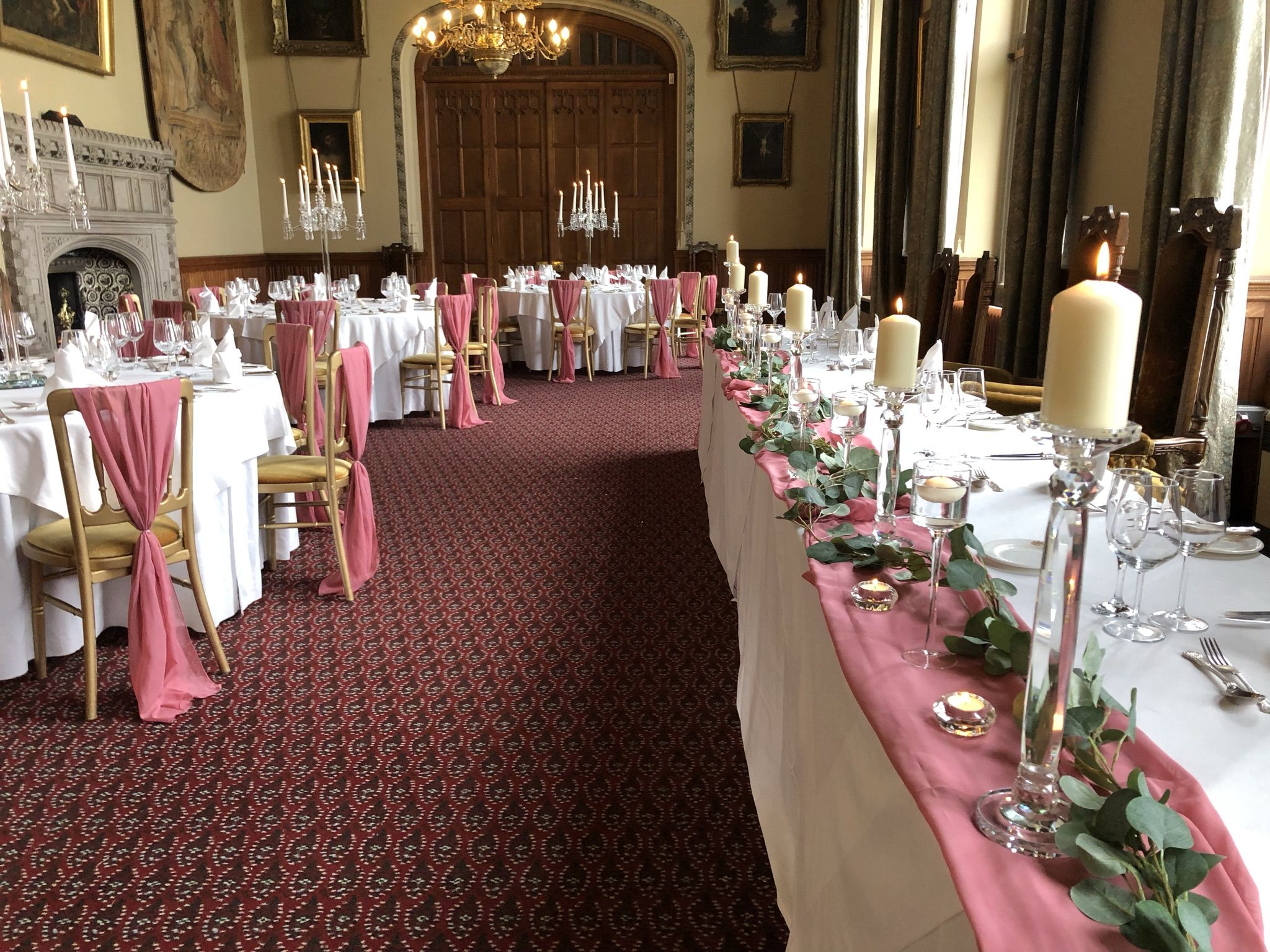 a banquet hall with tables and chairs covered in pink linens.