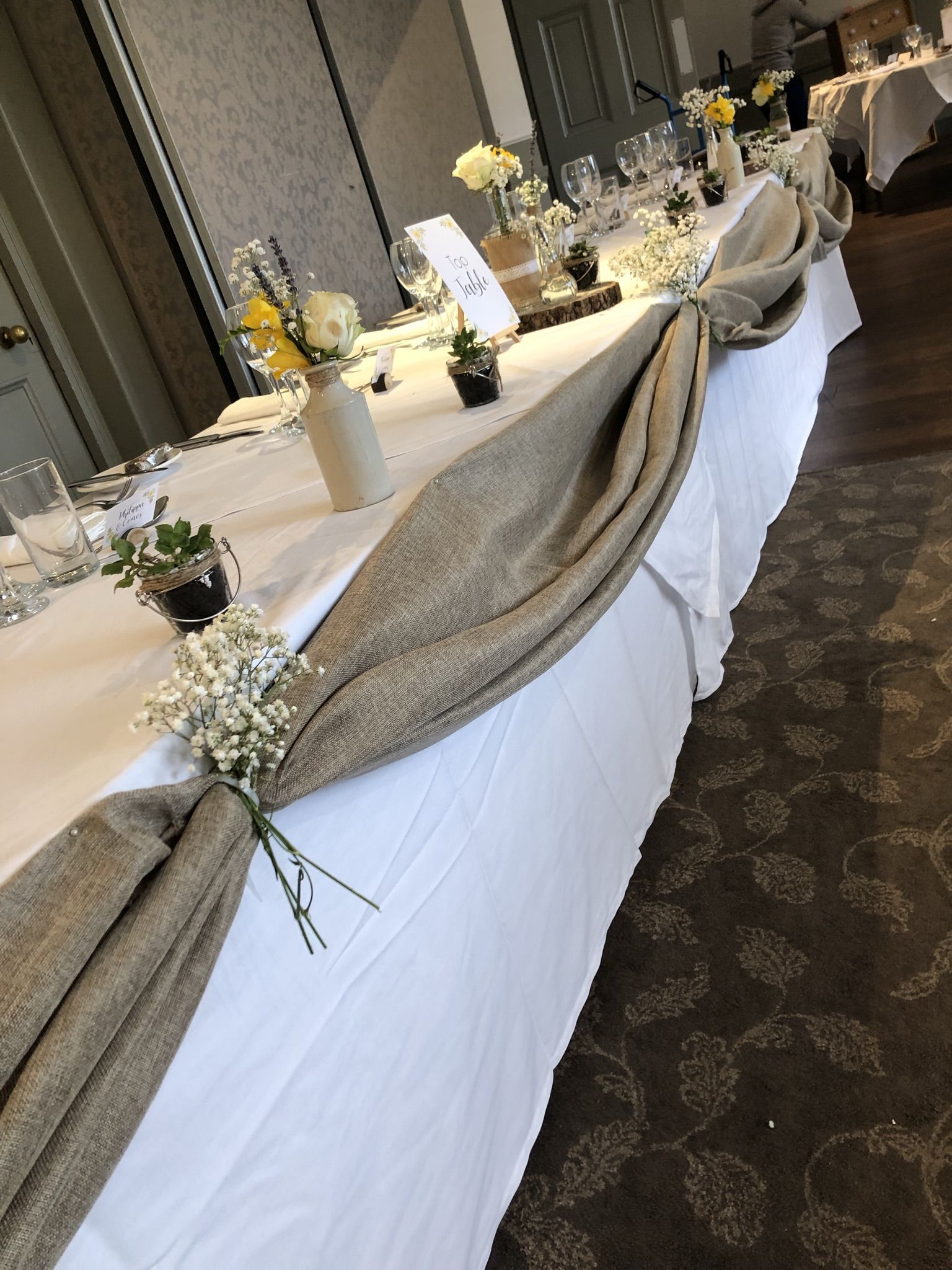 a long table with a white table cloth draped over it.