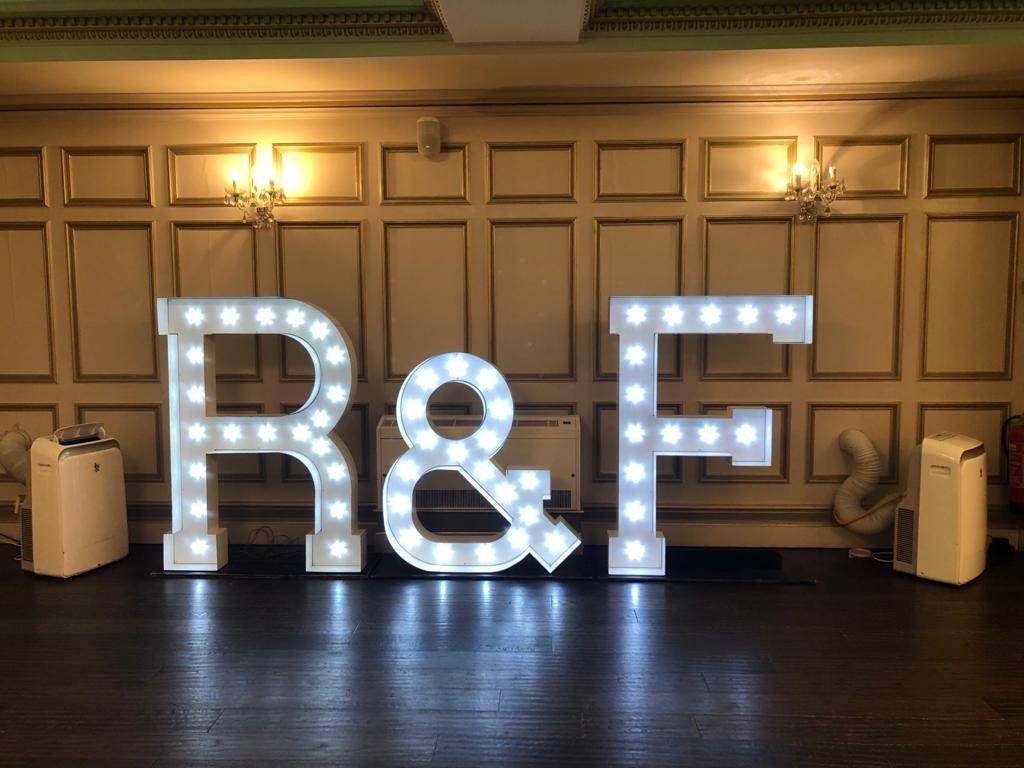 lighted letters spelling r and f on a wooden floor.