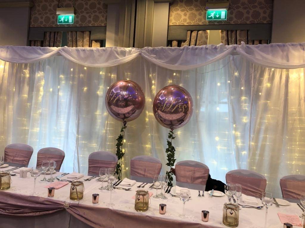 a table set up for a party with balloons.