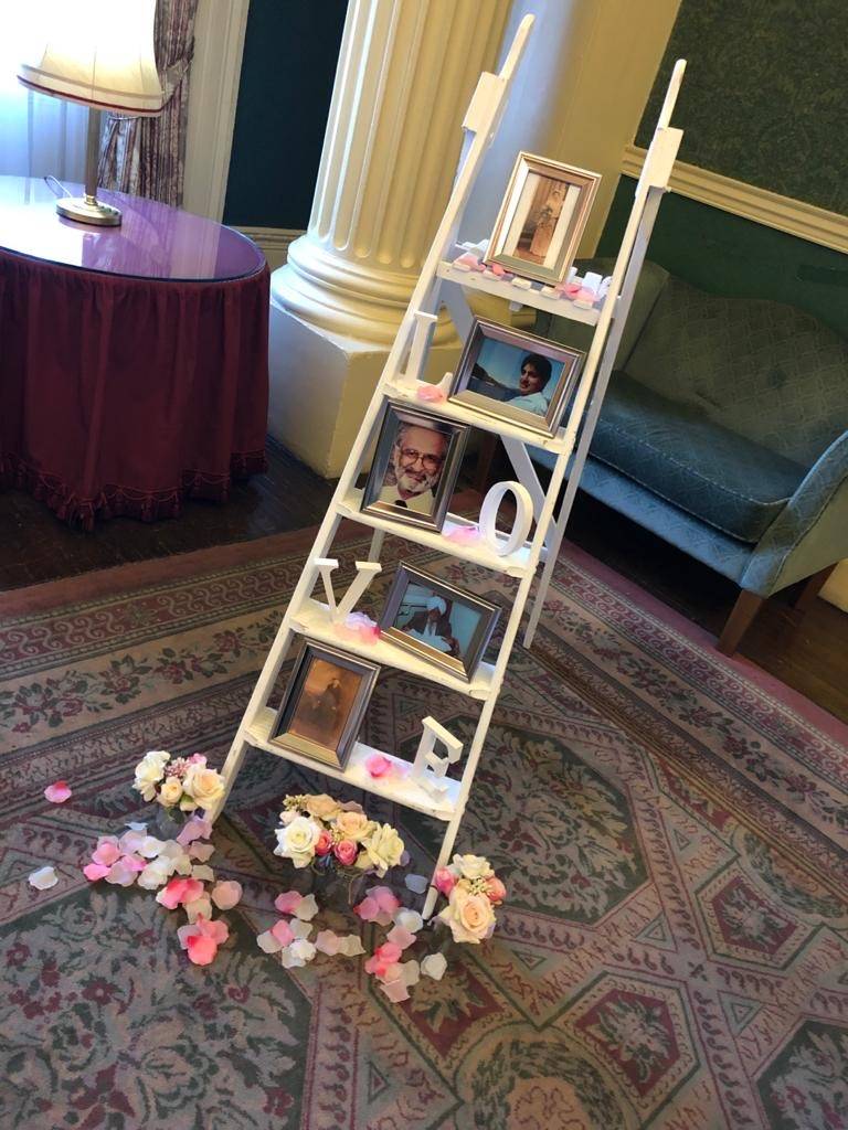 a ladder with pictures and flowers on it.