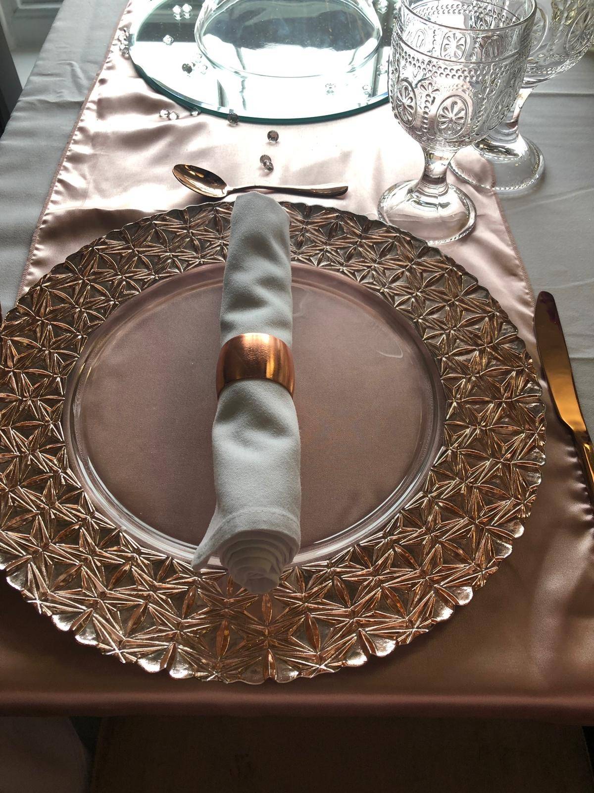 a place setting with a silver plate and silver napkin.