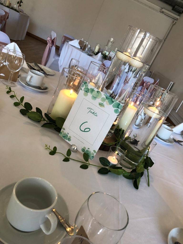 a table is set with candles and place cards.