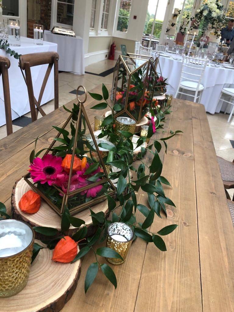 a wooden table topped with vases filled with flowers.