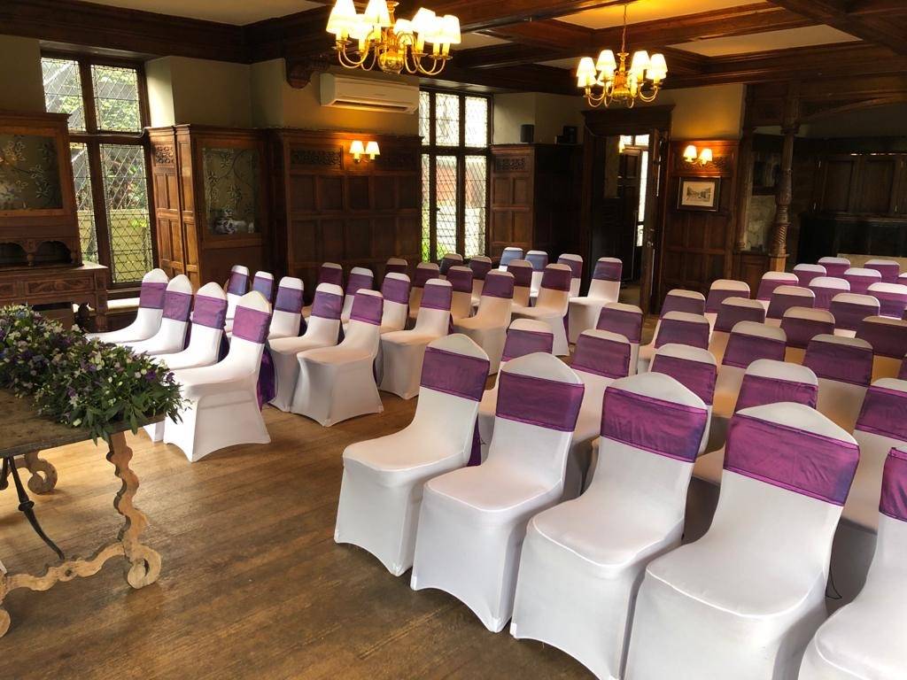 a room filled with lots of white and purple chairs.