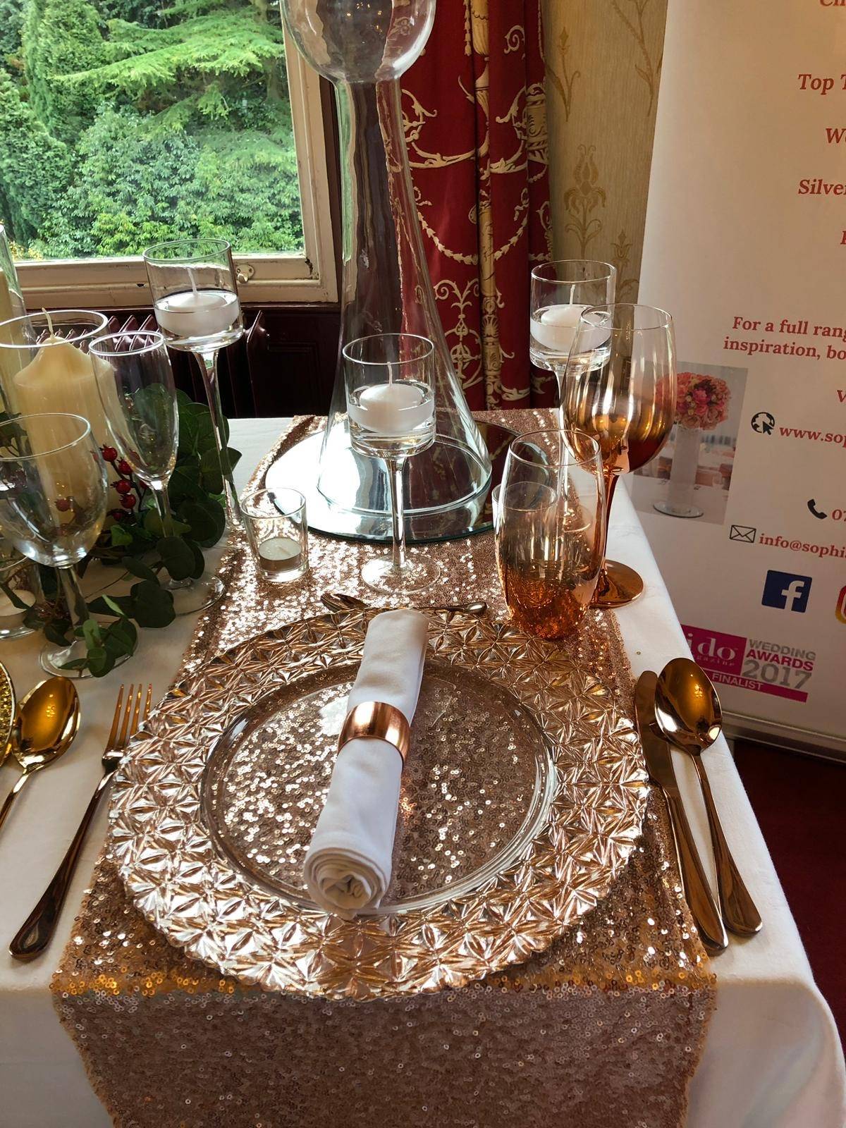 a table set for a formal dinner with wine glasses and silverware.