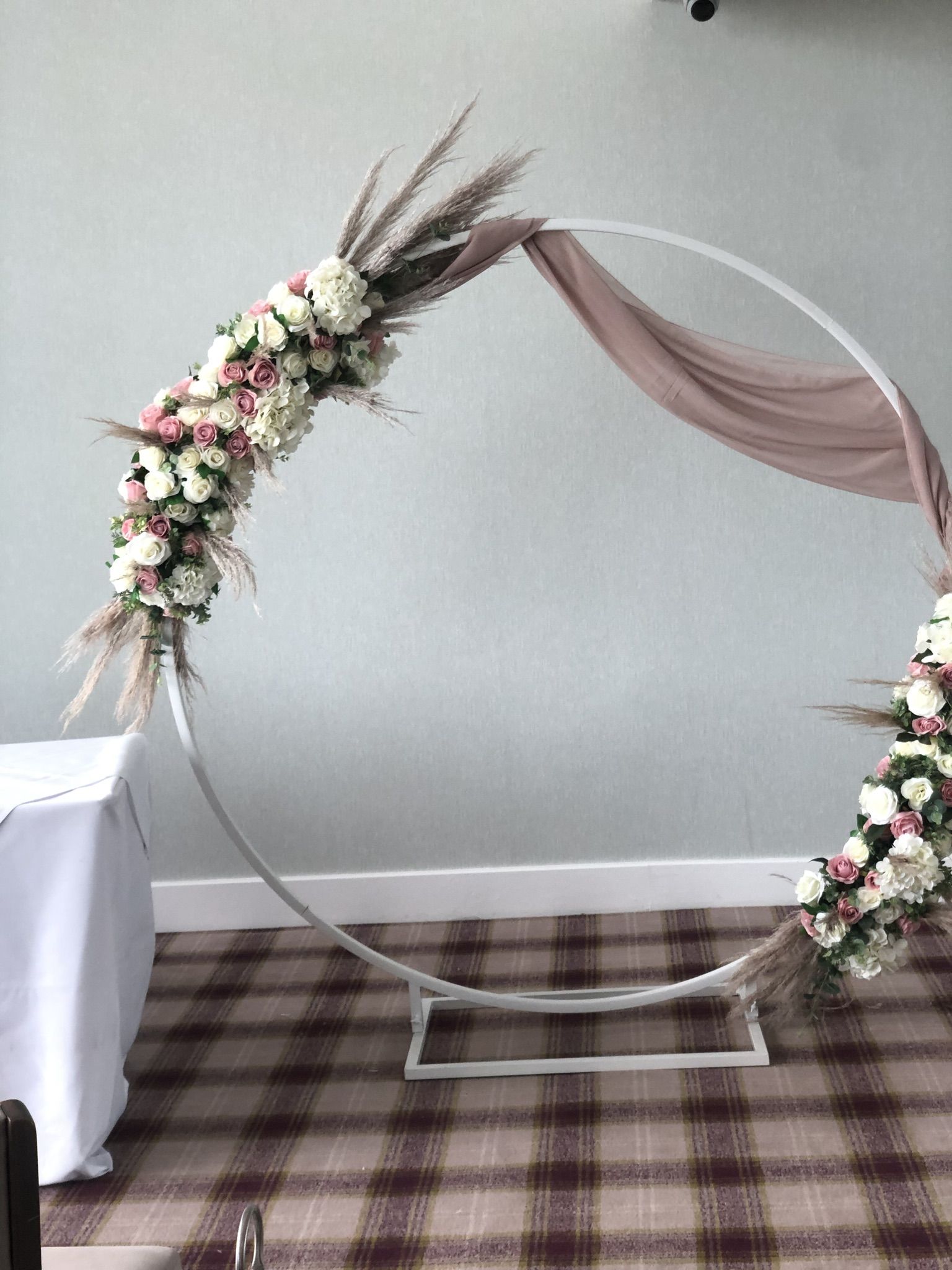 a wedding arch decorated with flowers and feathers.