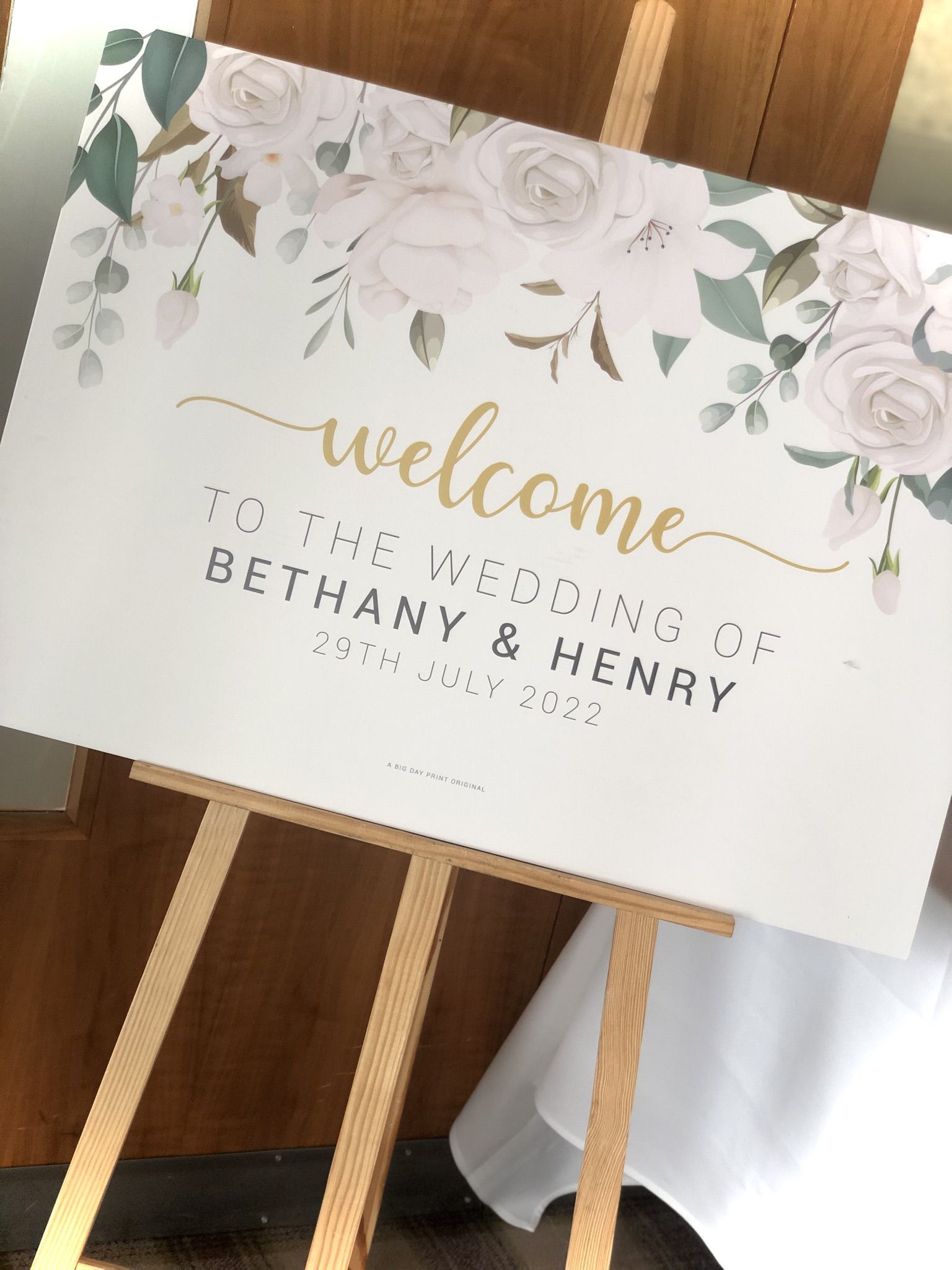 a wedding welcome sign on a wooden easel.