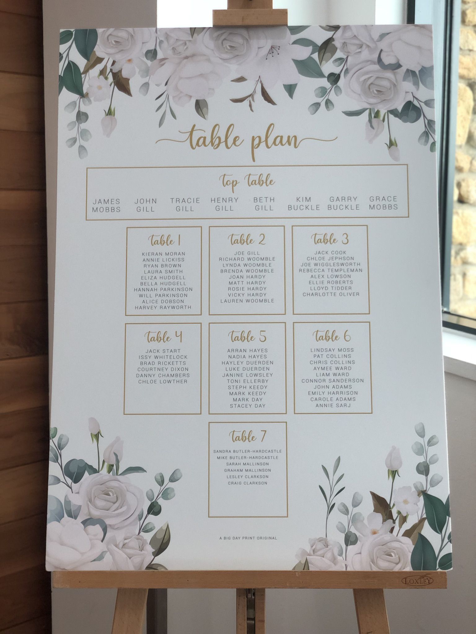 a table plan is displayed on a easel.