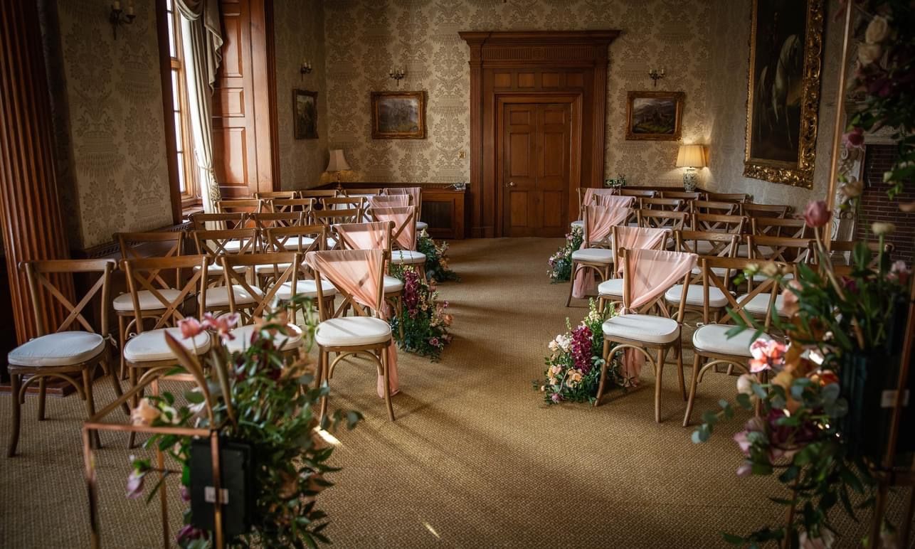 a room filled with lots of wooden chairs covered in flowers.
