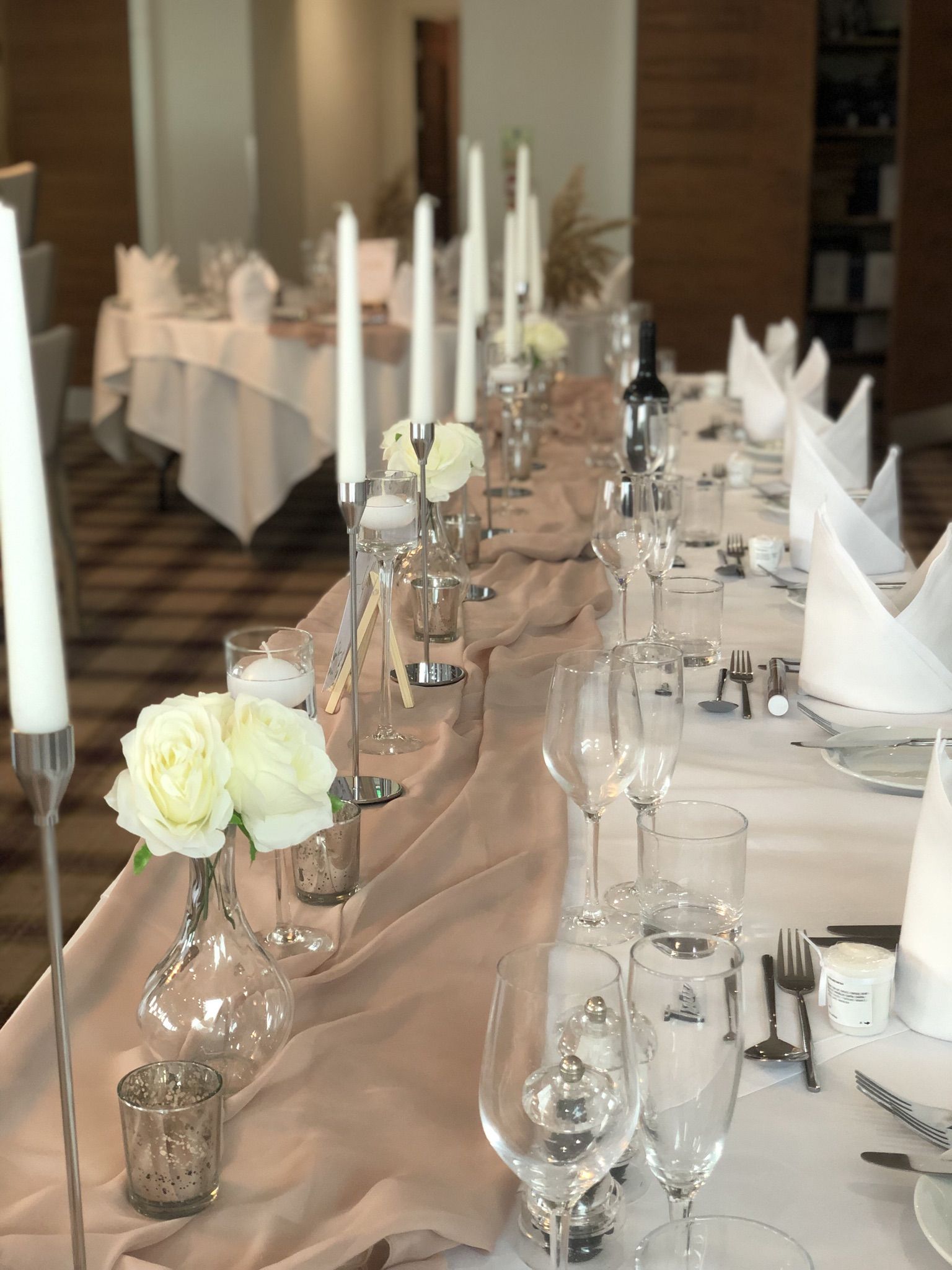 a long table with white flowers and candles.