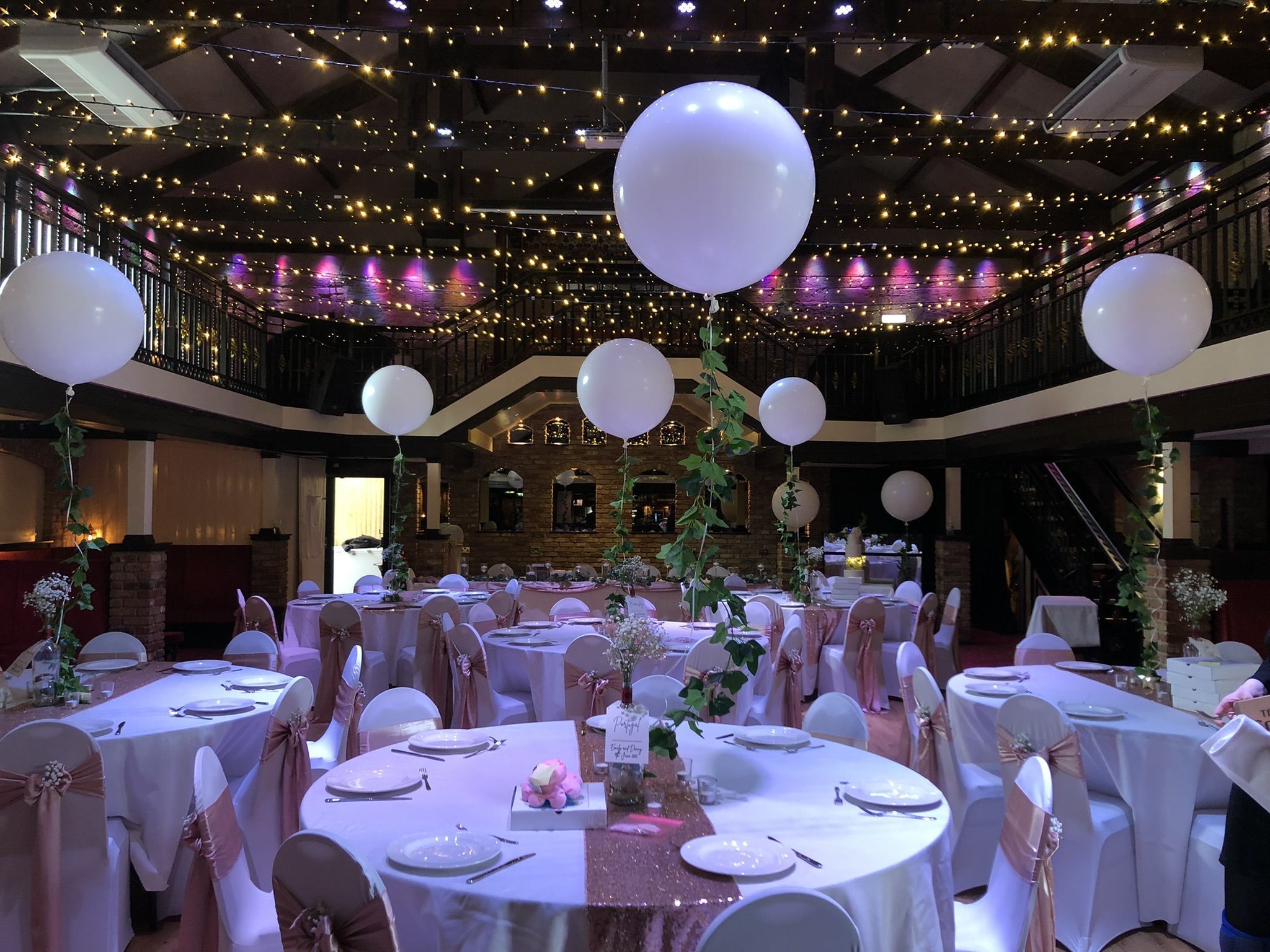 a banquet hall decorated with white and pink decorations.