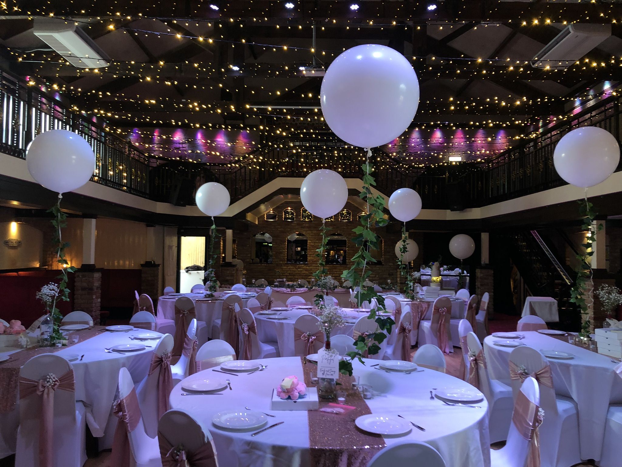 a banquet hall decorated with white and pink decorations.