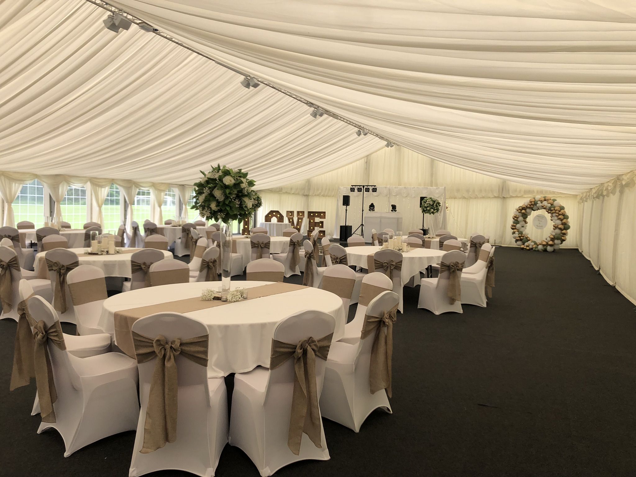 a large tent with tables and chairs set up for a wedding.