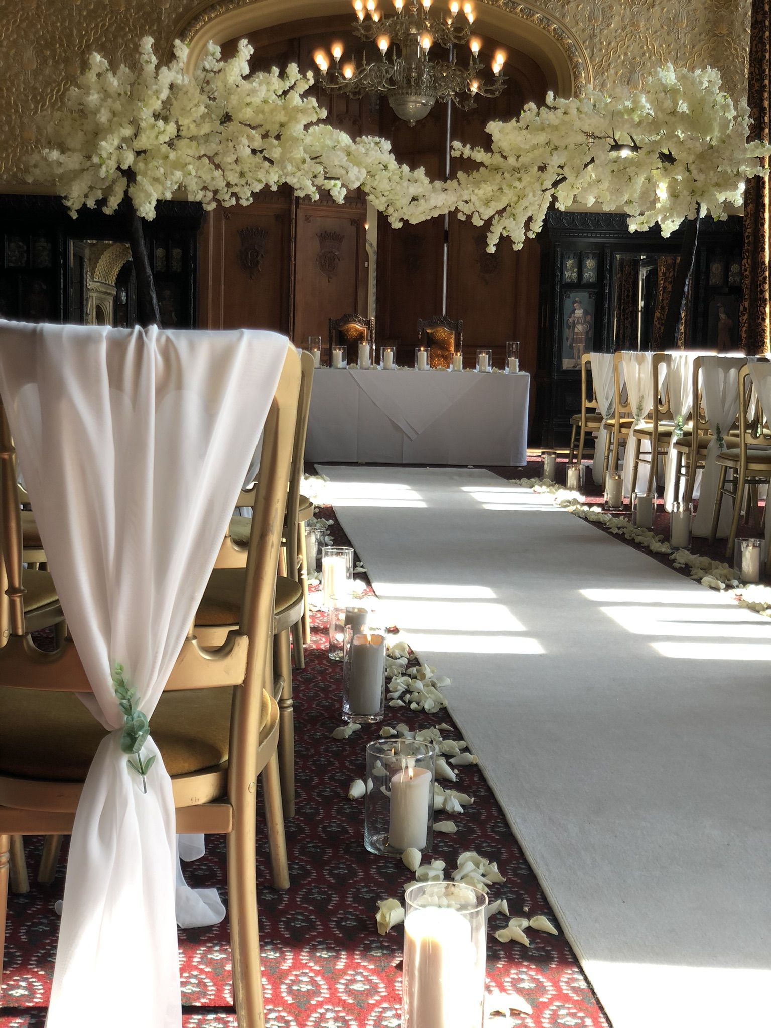 a long table with white flowers and candles on it.