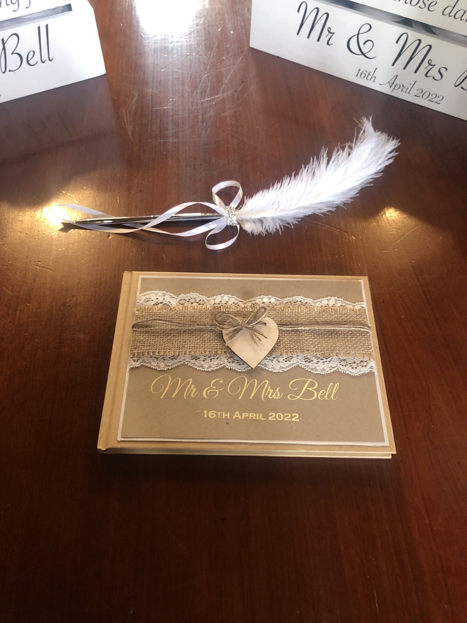 a wedding card with a feather on top of it.