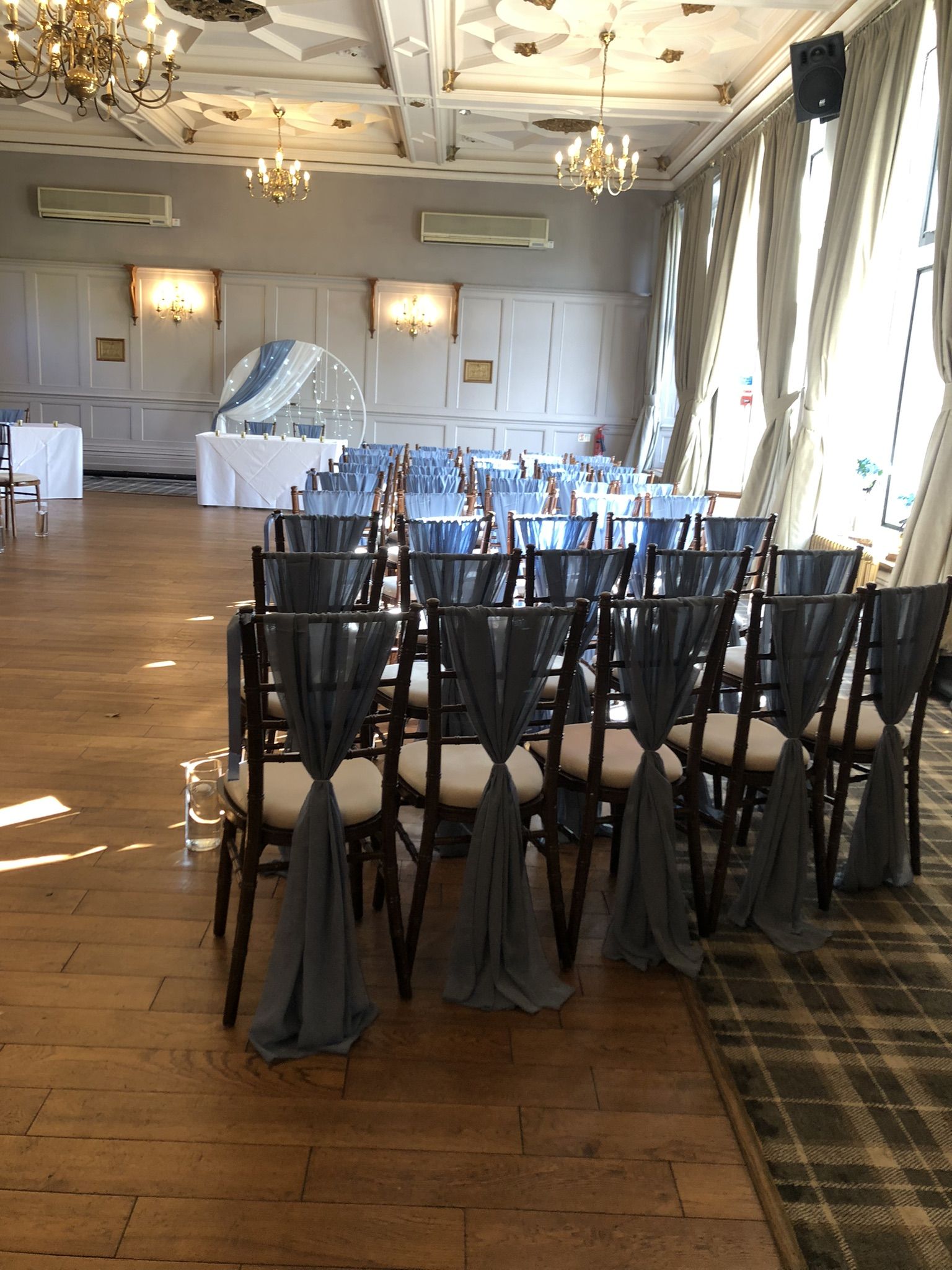 a large room with rows of chairs and a chandelier.