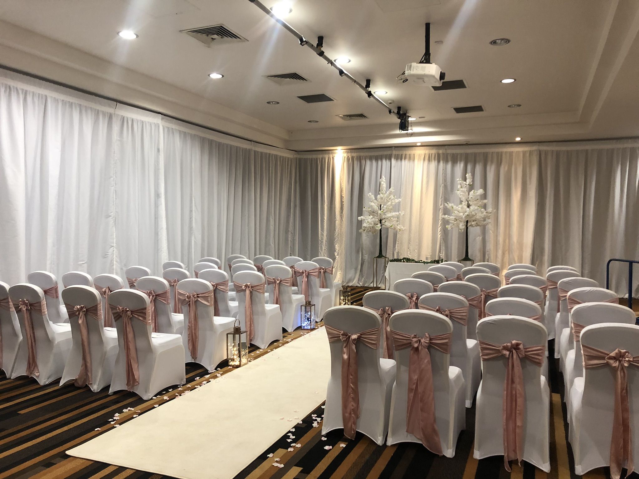 rows of white chairs with pink sashes and bows.