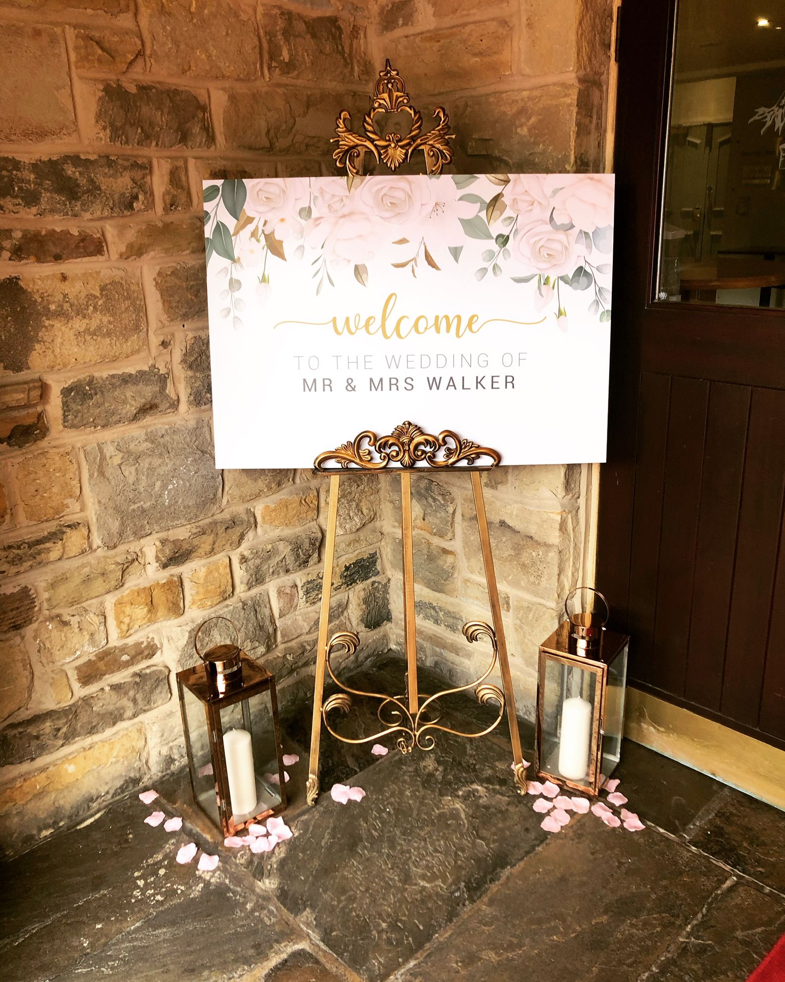 a welcome sign with candles and petals on the floor.