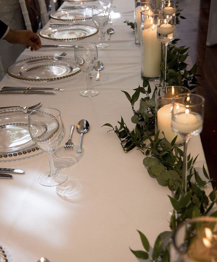a long table with candles and plates on it.