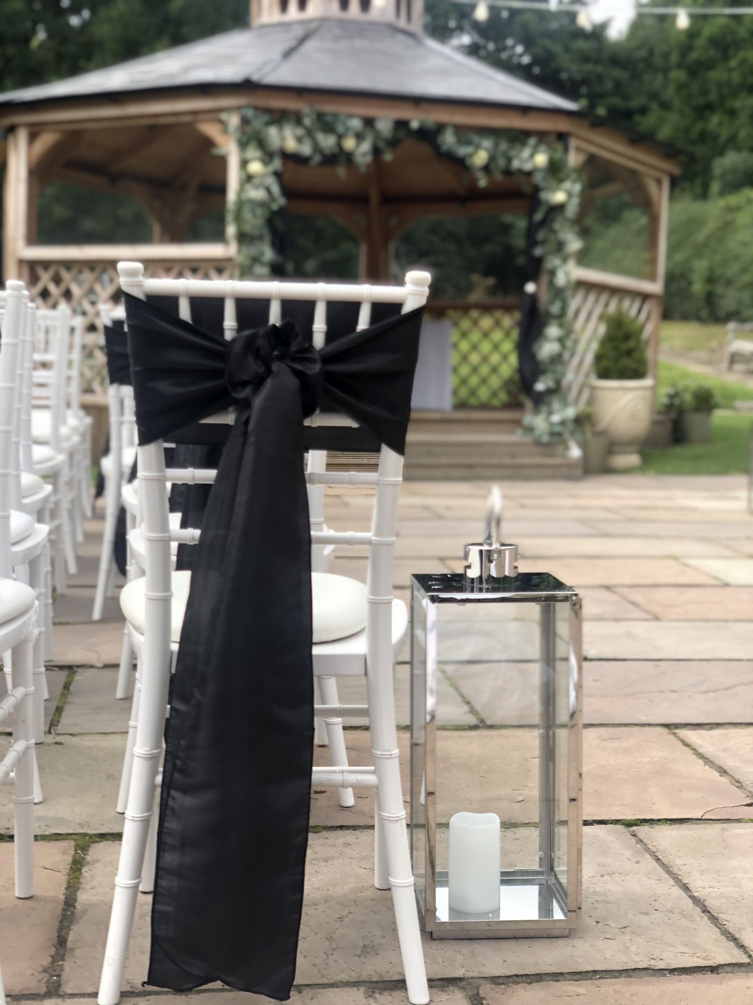 a black ribbon tied to a chair at a wedding.