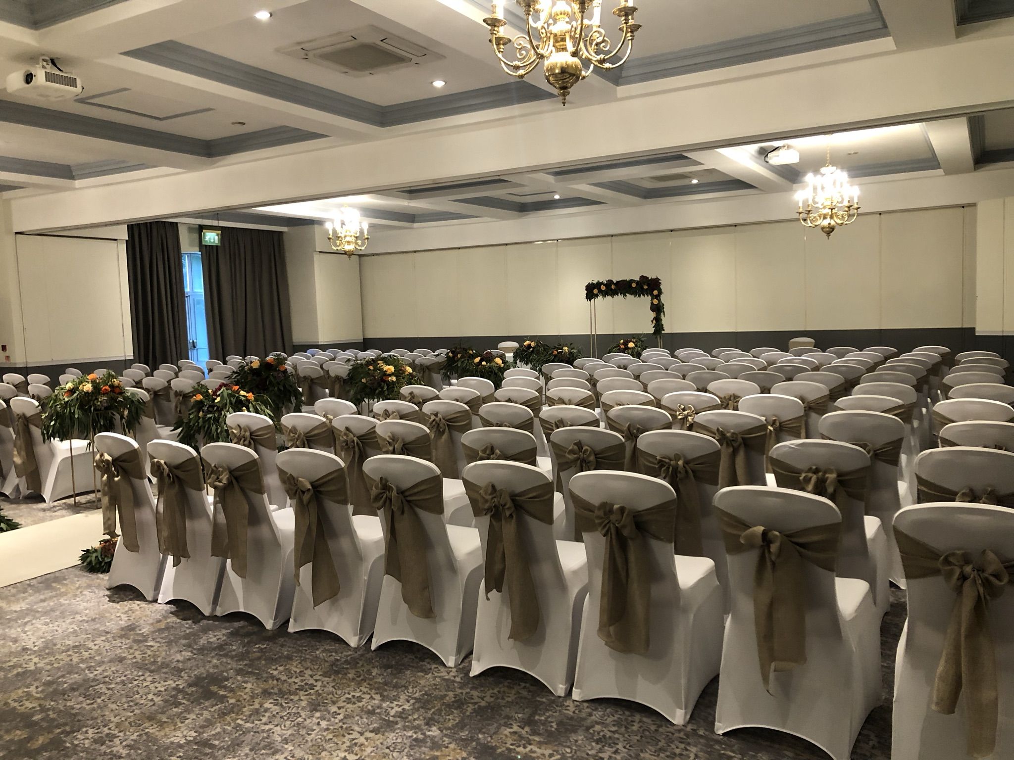 a room filled with lots of white chairs covered in bows.