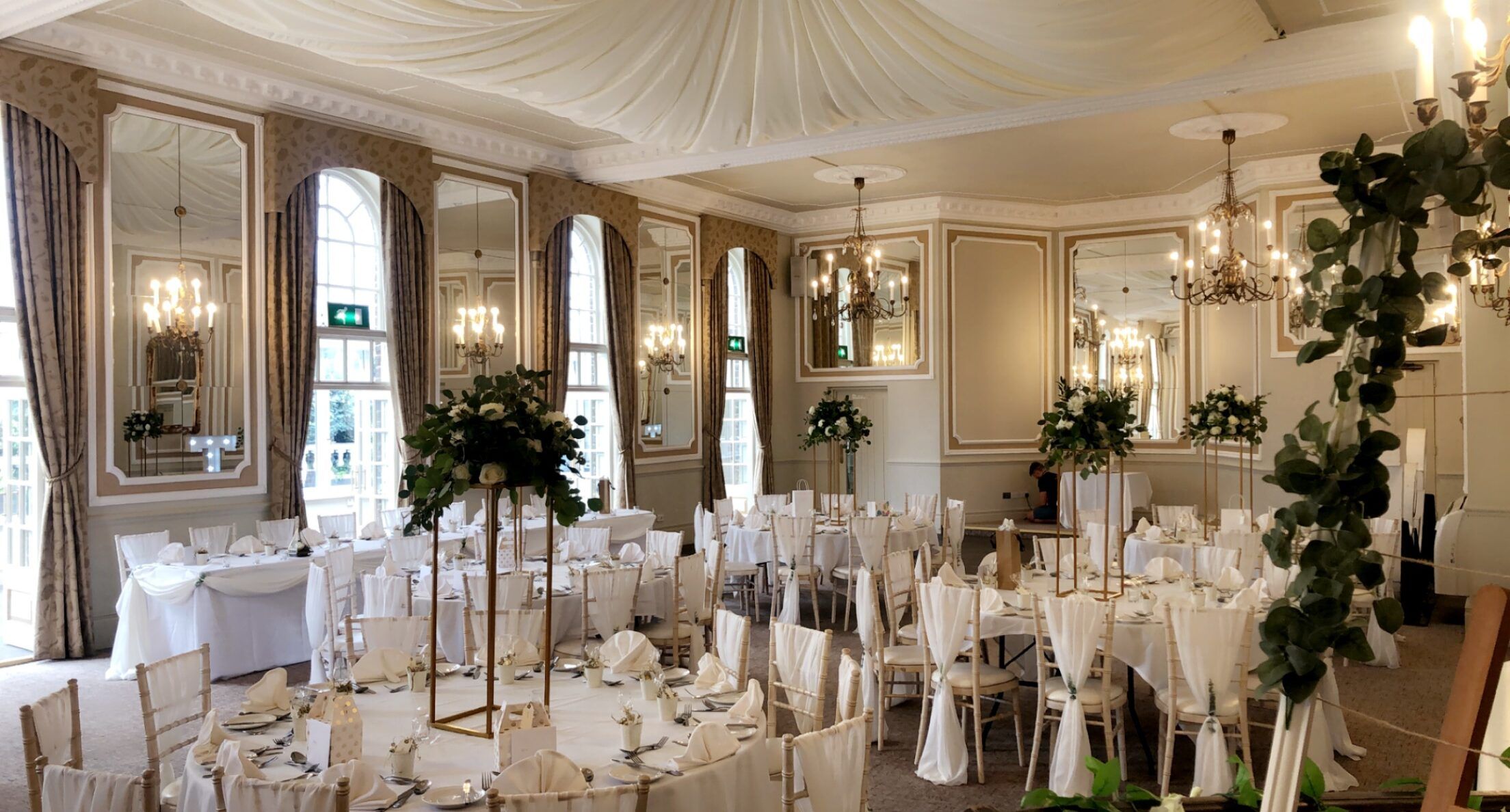 a room filled with lots of white tables and chairs.