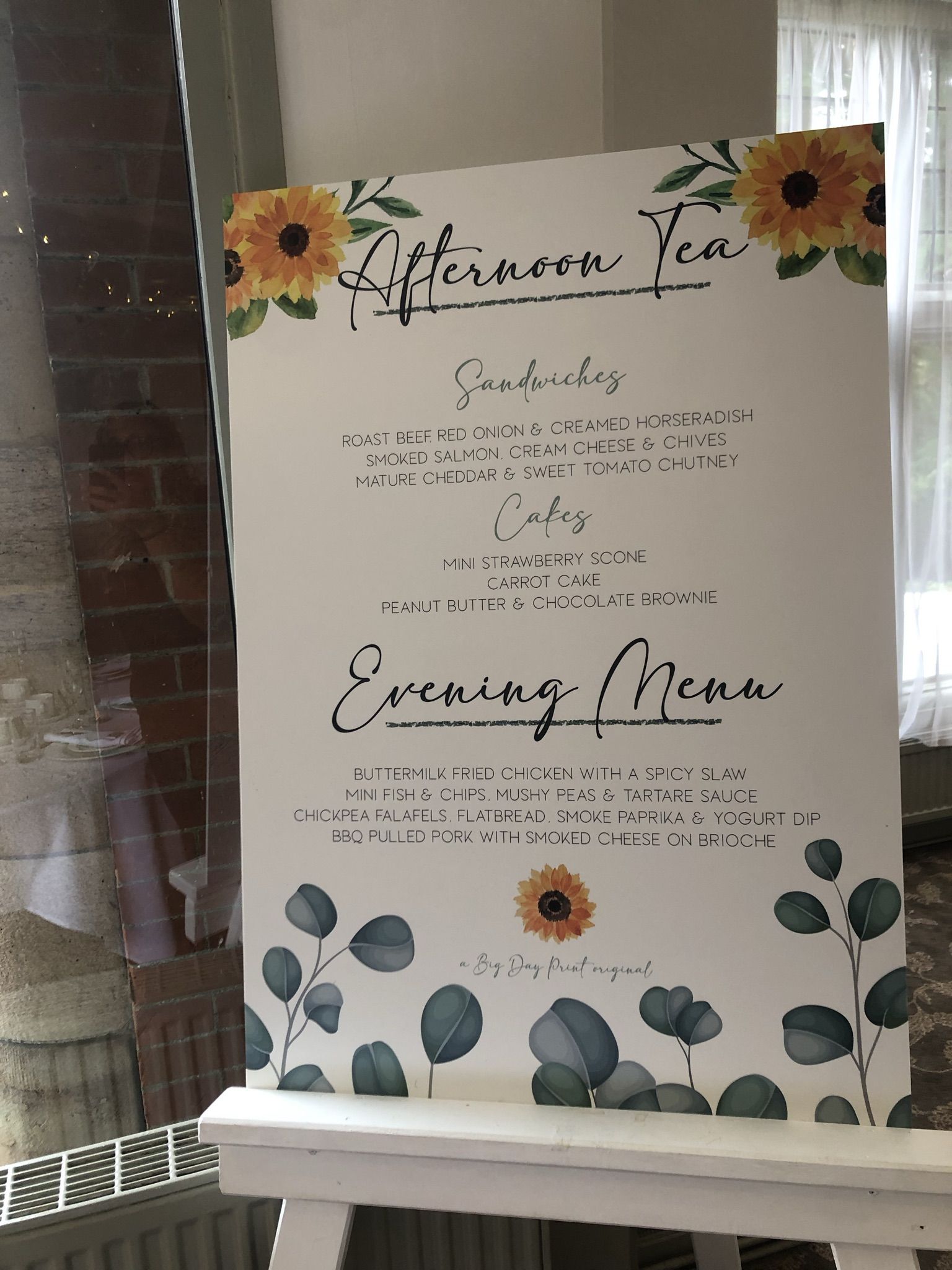 a white sign with sunflowers on it.