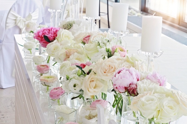 a row of vases filled with white and pink flowers.