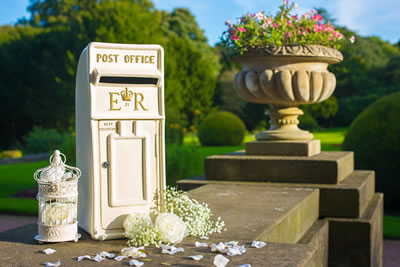 a post office sitting next to a flower pot.