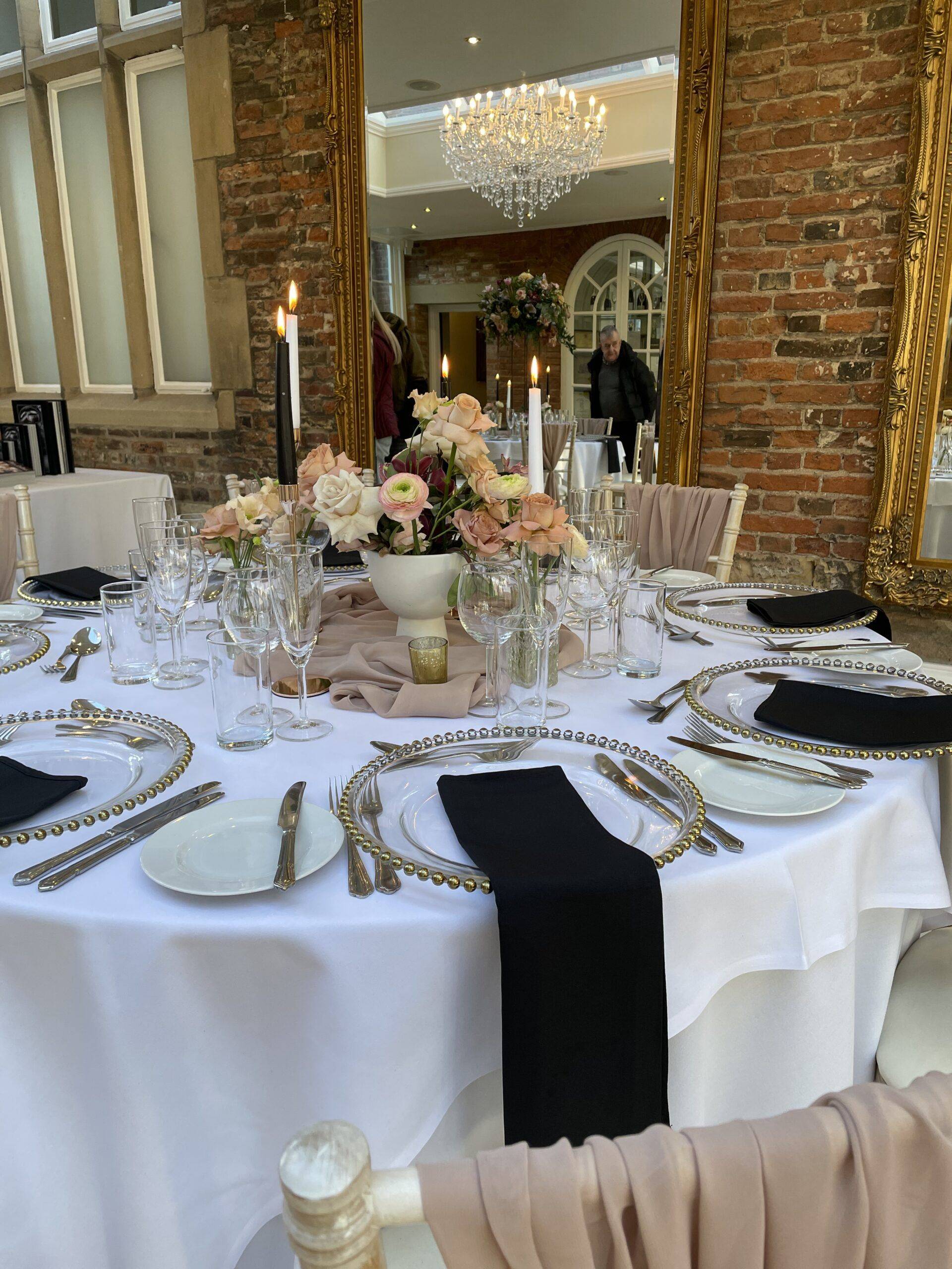 a table set for a formal dinner with flowers and candles.