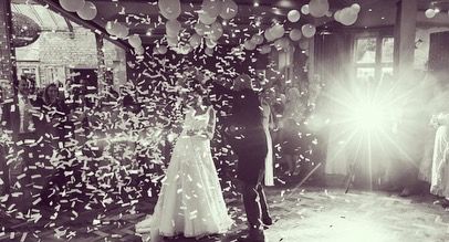 a bride and groom are surrounded by confetti.