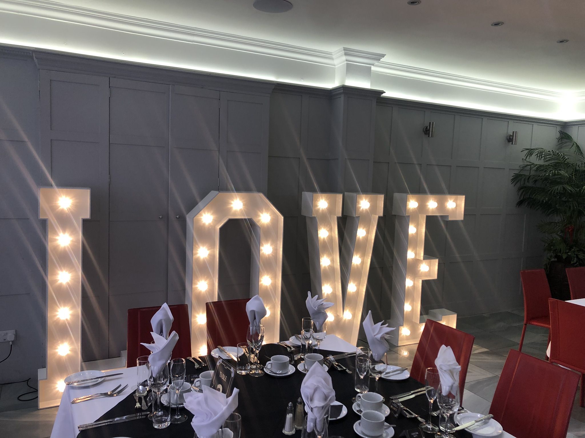 a table set up for a wedding with a love sign.