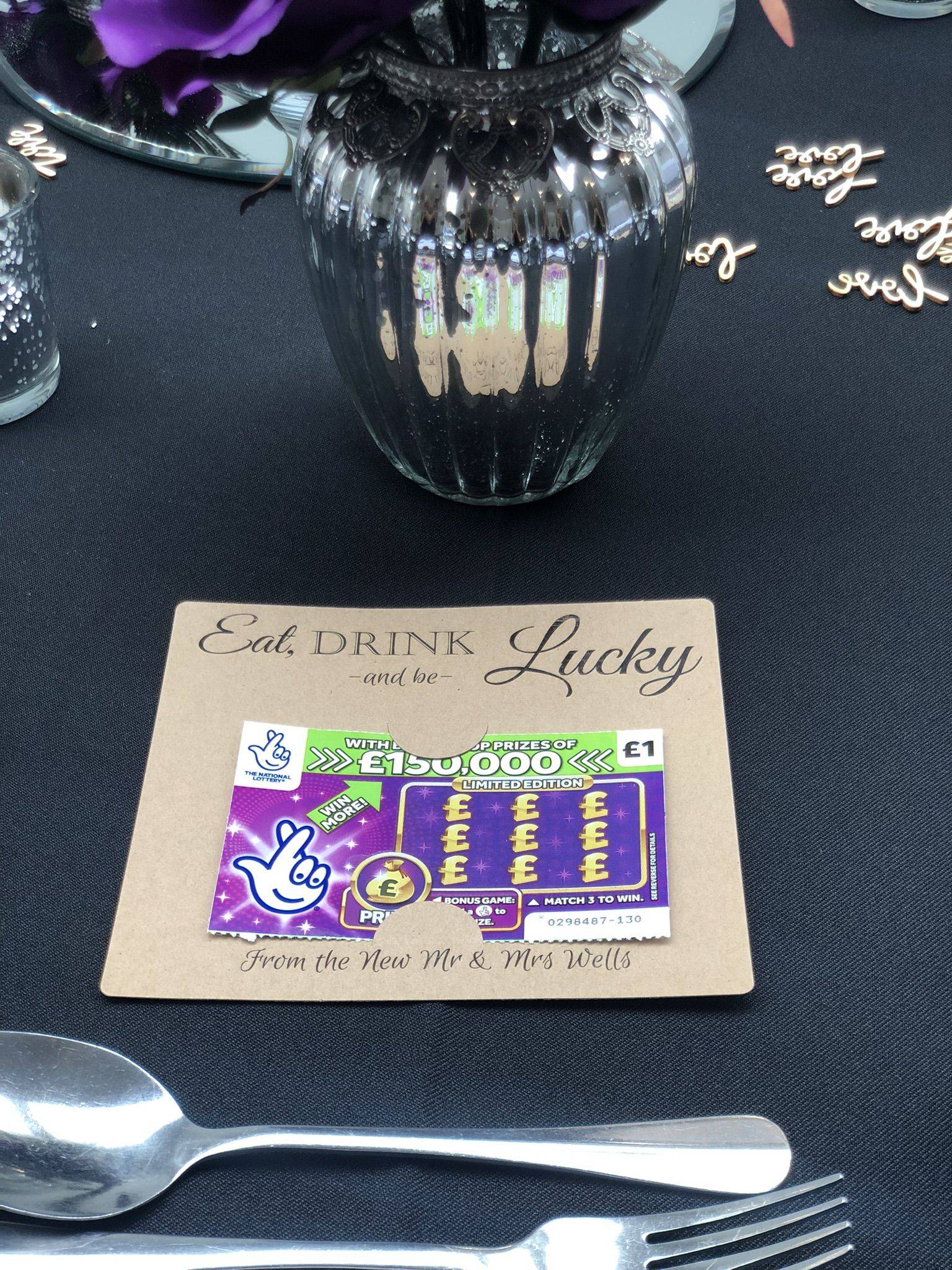 a place setting with silverware and purple flowers.