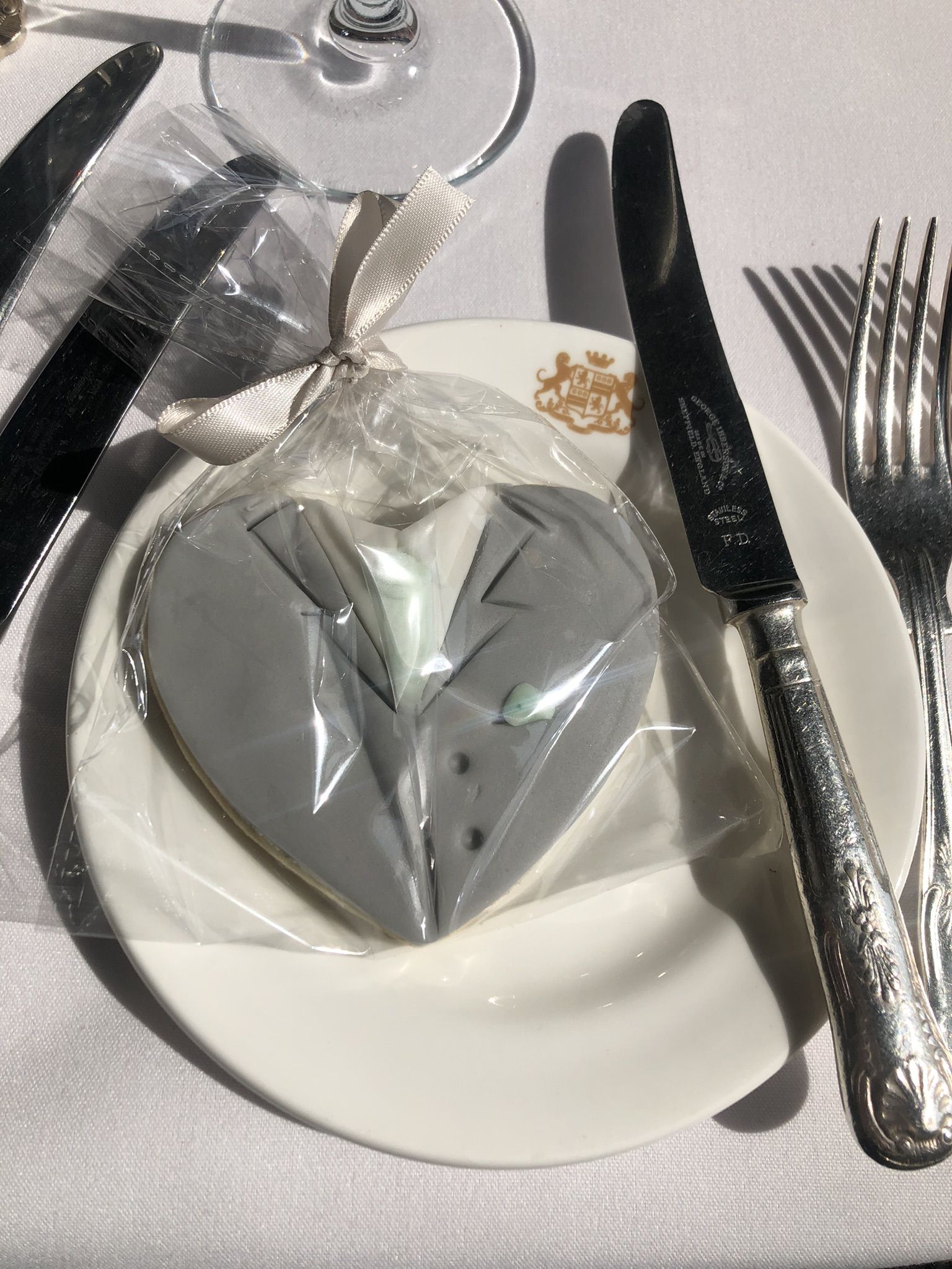 a white plate topped with silverware and a heart shaped napkin.